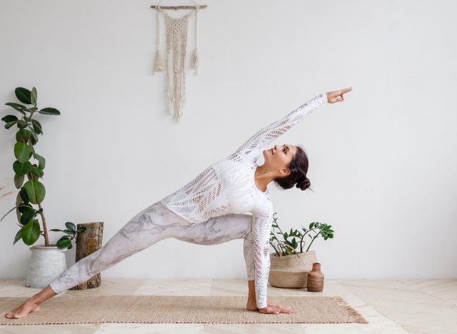 woman doing yoga stretches at home, demonstrating how to boost your mood in the winter